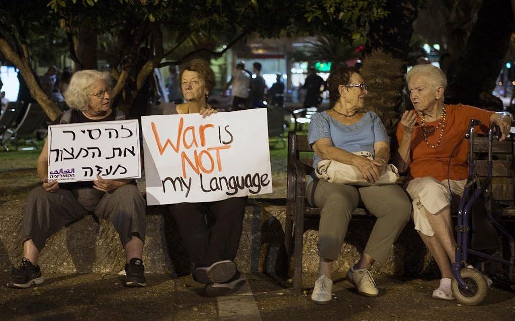 Israeli left wing activists hold placards during a demonstration against Israel's offensive in the Gaza Strip, in Tel Aviv, Israel, Saturday, August 9, 2014. (Photo credit: Danielle Shitrit/Flash90)