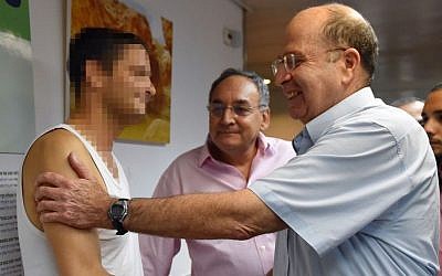 Defense Minister Moshe Ya'alon visits Israeli soldiers injured during Operation Protective Edge, at Tel Hashomer Hospital in Tel Aviv on August 11, 2014. (Photo credit: Ariel Hermoni/Ministry of Defense/Flash90)