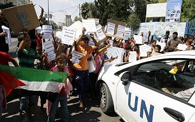 Palestinian children hold posters outside an UNRWA school in Gaza during a protest on August 11, 2014. (Abed Rahim Khatib/Flash90)
