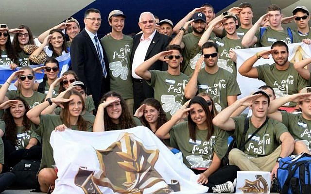Israeli president Reuven Rivlin (C) and Minister of Interior Affairs Gideon Saar (center left) welcome new immigrants from USA and Canada as they arrive in a special 'Soldier Aliyah Flight 2014' on behalf of the Jewish Agency and the Nefesh B'Nefesh organization, at Ben-Gurion Airport, August 12, 2014. (Israeli Defense Force).  (Mark Neyman/GPO/ FLASH90)