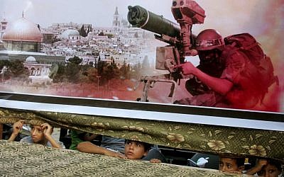 Palestinian children look on from behind a banner at a pro-Hamas rally in Rafah, southern Gaza Strip, August 17, 2014 (photo credit: Abed Rahim Khatib/Flash90)