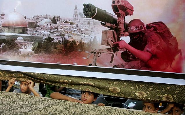 Palestinian children look on from behind a banner at a pro-Hamas rally in Rafah, southern Gaza Strip, August 17, 2014 (photo credit: Abed Rahim Khatib/Flash90) Palestinian children look on from behind a banner at a pro-Hamas rally in Rafah, southern Gaza Strip, August 17, 2014 (photo credit: Abed Rahim Khatib/Flash90)