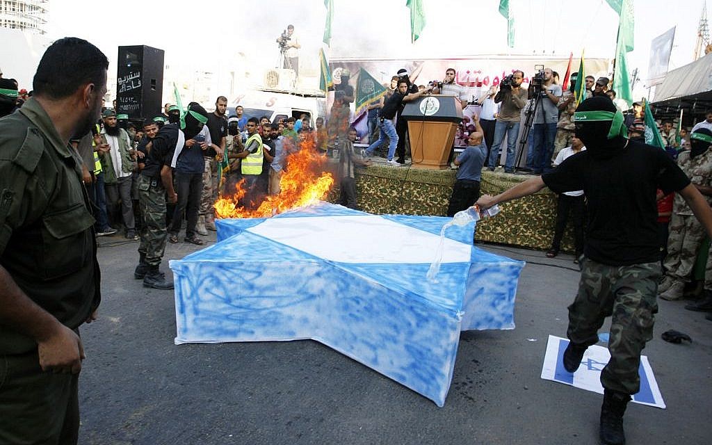 Masked Hamas members burn a cut-out of a Star of David during a Hamas demonstration August 17, 2014 in Rafah, Gaza Strip. (Photo credit: Abed Rahim Khatib/Flash90)