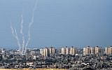 Illustrative: The Israel-Gaza border, from the Israeli side, with rockets being fired by Palestinian terrorists from the Gaza Strip into Israel, August 20, 2014. (Albert Sadikov/Flash90)