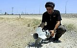 A man holds part of a rocket that exploded and fell inside the Israeli border with the Gaza Strip on August 20, 2014. (photo credit: Edi Israel/Flash90)