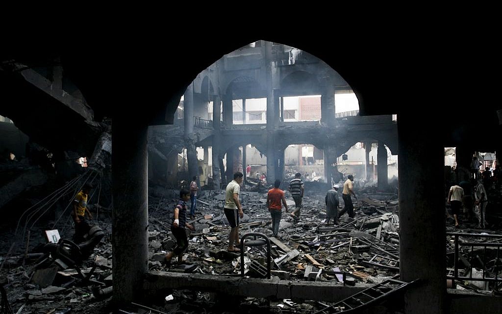Palestinians inspect the rubble of a destroyed shopping center after an Israeli airstrike overnight in the southern Gaza Strip city of Rafah, on August 24, 2014. (Abed Rahim Khatib/Flash90)