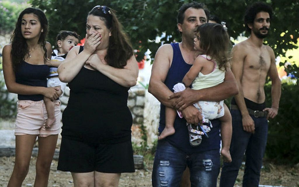 Residents look on in shock after a rocket fired from the Gaza Strip hit a house in Ashkelon, southern Israel, early morning on August 26, 2014. (photo credit: Edi Israel/Flash90)