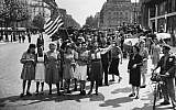 This Aug. 25, 1944 file photo shows French civilians with their hastily made American and French flags singing the "Star Spangled Banner" as they greet U.S. and Free French troops entering Paris, France, after Allied liberation of the French capital from Nazi occupation in World War II. (photo credit: AP Photo/Harry Harris, file)