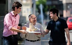 In this Friday, July 4, 2014 photo, Protestant priest Gregor Hohberg, Rabbi Tovia Ben-Chorin and Imam Kadir Sanci, from left, show a model of the planned prayer and education building House of One prior to an interview with The Associated Press in Berlin. House of One will house a synagogue, a Christian church and a mosque. (AP Photo/Markus Schreiber)