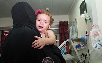 Two-year-old Hala Arada with her grandmother Haniyah Shaer at Wolfson Hospital in Holon, August 12, 2014. Hala has congenital heart disease and is being treated in Israel. Two members of her family were recently killed in an Israeli air strike in Gaza.  (photo credit: Sheila Shalhevet/Save a Childs Heart)