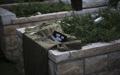 The grave of IDF soldier Lee Matt, seen during the vigil ceremony at the Mount Herzl Military Cemetery in Jerusalem, August 21, 2014. A sticker on his grave, which reads 'Let me die in peace,' was made by his family as a protest against army regulations on what gets written on the soldier's tombstone. (photo credit: Hadas Parush/Flash90)