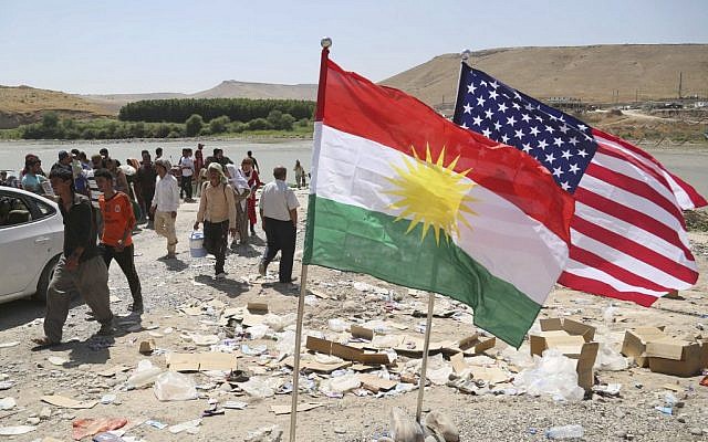 US and Kurdish flags flutter in the wind while displaced Iraqis from the Yazidi community cross the Syria-Iraq border at Feeshkhabour bridge over the Tigris River at Feeshkhabour border point, in northern Iraq, on Sunday, August 10, 2014. (photo credit: AP/Khalid Mohammed) US and Kurdish flags flutter in the wind while displaced Iraqis from the Yazidi community cross the Syria-Iraq border at Feeshkhabour bridge over the Tigris River at Feeshkhabour border point, in northern Iraq, on Sunday, August 10, 2014. (photo credit: AP/Khalid Mohammed)