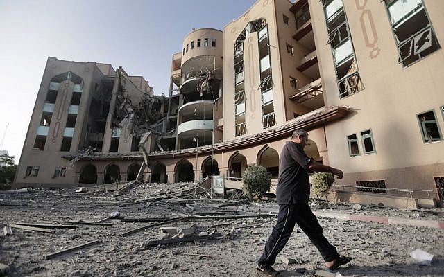 An Islamic University guard inspects the damage to the institution, hit in an overnight Israeli strike, in Gaza City, northern Gaza Strip, Saturday, Aug. 2, 2014. Israel said the institution was used for weapons research and manufacture. (AP Photo/Lefteris Pitarakis)