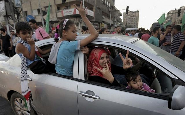 A Palestinian family flashes victory signs as they celebrate the ceasefire between Palestinians and Israelis at the main road in Gaza, in the northern Gaza Strip, Tuesday, Aug. 26, 2014. (photo credit: AP Photo/Adel Hana) A Palestinian family flashes victory signs as they celebrate the ceasefire between Palestinians and Israelis at the main road in Gaza, in the northern Gaza Strip, Tuesday, Aug. 26, 2014. (photo credit: AP Photo/Adel Hana)