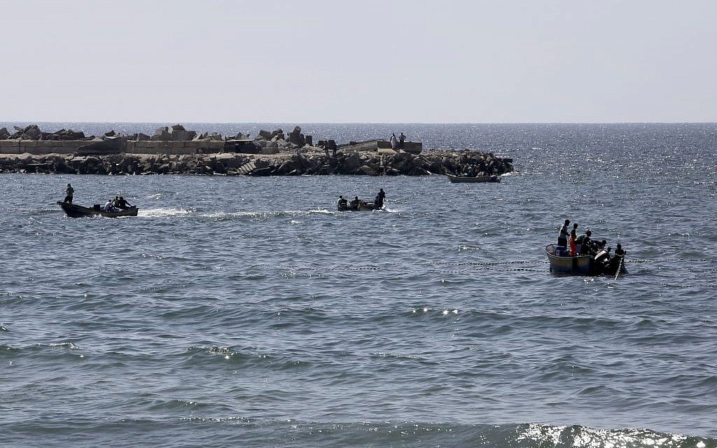 Palestinian fishermen sail to fish as others pull their fishnet at the Mediterranean Sea in Gaza City in the northern Gaza Strip on Thursday, Aug. 7, 2014. (photo credit: AP Photo/Adel Hana)