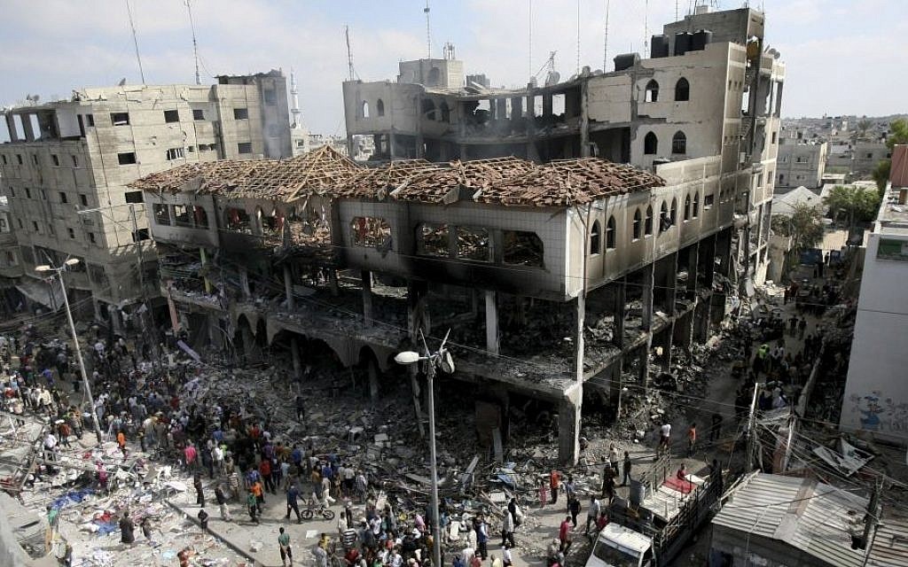 Palestinians inspect the damage to a commercial center after an Israeli strike in Rafah, in the southern Gaza Strip, Aug. 24, 2014. (photo credit: AP Photo/Eyad Baba)