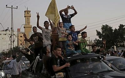 Gazans celebrate the Israel-Hamas ceasefire, in the northern Gaza Strip, Tuesday, Aug. 26, 2014.  (photo credit: AP Photo/Adel Hana)