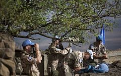 UN peacekeepers from the United Nations Disengagement Observer Force, also known as UNDOF, observe Syria's Quneitra province at an observation point on Mount Bental in the Israeli-controlled Golan Heights, overlooking the border with Syria, Friday, August 29, 2014. (photo credit: AP/Ariel Schalit)