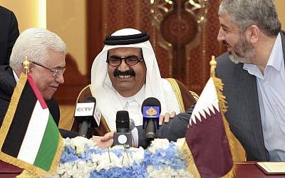 In this Monday, February 6, 2012 file photo, Palestinian President Mahmoud Abbas, left, shakes hands with Hamas leader Khaled Mashaal, right, as the then Emir of Qatar, Sheik Hamad bin Khalifa Al Thani, looks on after signing an agreement in Doha, Qatar. (photo credit: AP/Osama Faisal, File)