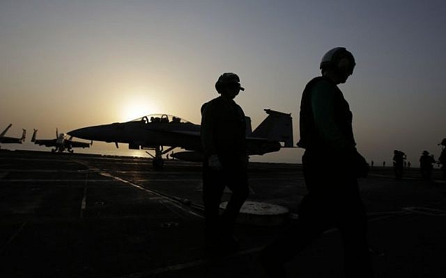Pilots walk at sunset on the flight deck of the US Navy aircraft carrier USS George H.W. Bush on Sunday, Aug. 10, 2014 in the Persian Gulf. (Photo credit: AP/Hasan Jamali) Pilots walk at sunset on the flight deck of the US Navy aircraft carrier USS George H.W. Bush on Sunday, Aug. 10, 2014 in the Persian Gulf. (Photo credit: AP/Hasan Jamali)