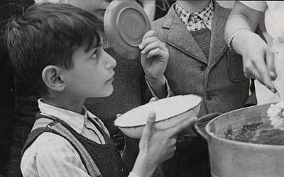 A young refugee who fled Nazi-occupied France to Switzerland through the Alps, is receiving food in a JDC supported facility. He was then sent to a children's home, also supported by JDC. c. 1943 (courtesy)