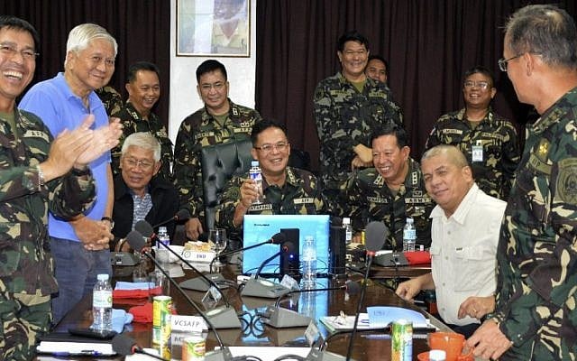 In this photo released by the Armed Forces of the Philippines Public Affairs Office, Philippine Military Chief Gen. Gregorio Catapang, center, reacts after learning about the safe repositioning of Filipino peacekeepers in Golan Heights as they monitor the situation with Philippine Foreign Affairs Secretary Albert Del Rosario, second left, Philippine National Defense Secretary Voltaire Gazmin, third from left seated, at Camp Aguinaldo military headquarters in suburban Quezon city, Philippines on Saturday, Aug. 30, 2014. (photo credit: AP Photo/Armed Forces of the Philippines Public Affairs Office)