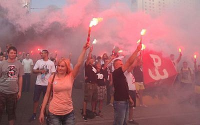 People hold burning flares to commemorate the 70. anniversary of the 1944 Warsaw Uprising in Warsaw, Poland, Friday, Aug. 1, 2014.  (AP Photo/Czarek Sokolowski)