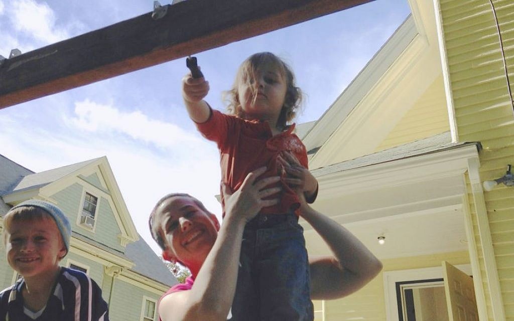 One of Havurat Shalom's younger members helps out with construction of the sukkah, September 2013. (Emily Aviva Kapor/JTA)