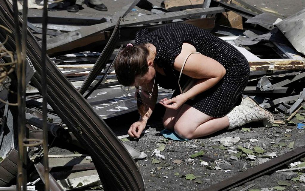 A local woman collects fragments of a shell after night shelling on a local market, in Donetsk, eastern Ukraine, Wednesday, Aug. 6, 2014. (AP Photo/Sergei Grits) A local woman collects fragments of a shell after night shelling on a local market, in Donetsk, eastern Ukraine, Wednesday, Aug. 6, 2014. (AP Photo/Sergei Grits)