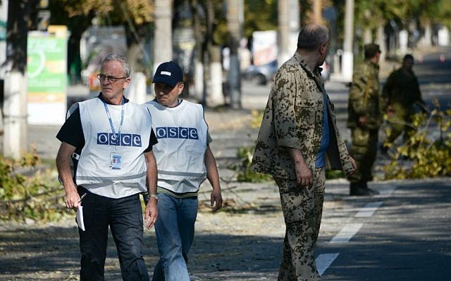 Members of the Organization for Security and Co-operation in Europe examine the scene of a shelling in the town of Donetsk, eastern Ukraine, Wednesday, Aug. 27, 2014. (photo credit: AP/Mstislav Chernov) 