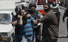 Undercover Israeli police officers detain a Palestinian suspected of throwing stones in the East Jerusalem neighborhood of Wadi al-Joz, August 1, 2014. (photo credit: Sliman Khader/Flash90)