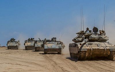 Israeli tanks and armored personnel carriers (APCs) drive at an unspecified location next to the Israel-Gaza Strip border, after pulling back from the Gaza Strip on August 3, 2014. (Flash90)