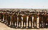 Israeli soldiers sing as they embrace each other at a staging area in southern Israel near the border with Gaza, as Israeli forces prepare to pull back from the area, on August 06, 2014. (Miriam Alster/Flash90)