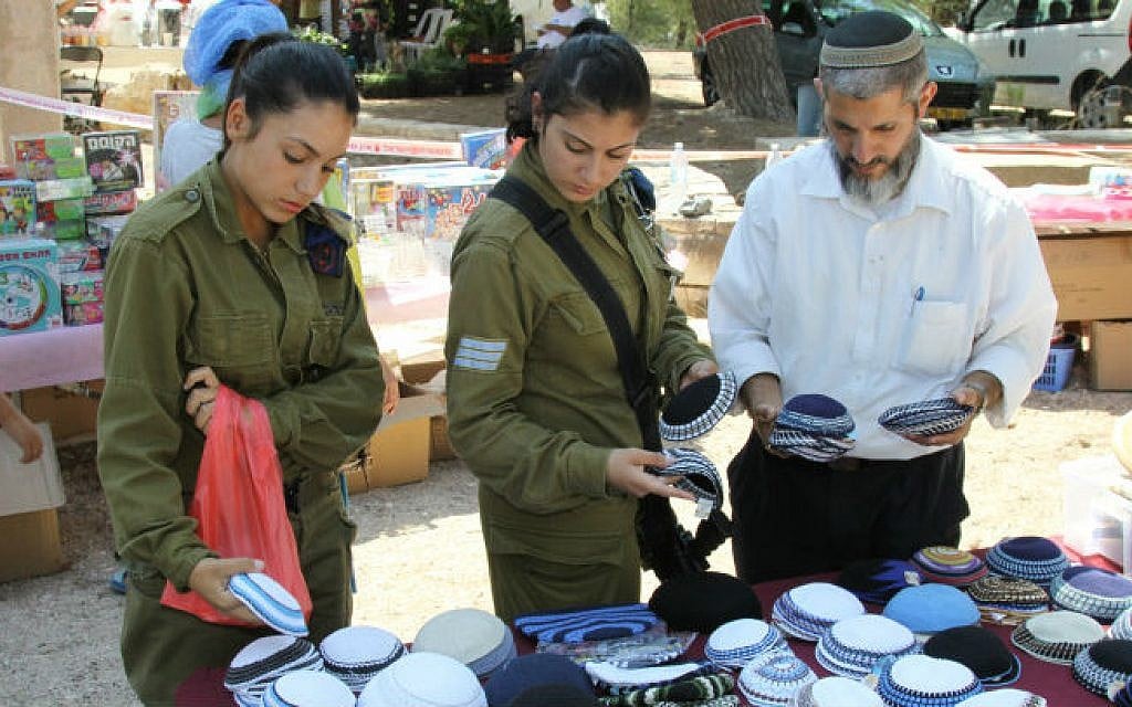 Israelis soldiers shop at a market organized in benefit of the businesses in Southern Israel, in the Israeli settlement of Har Gilo on August 15, 2014 (photo credit: Gershon Elinson/Flash90)