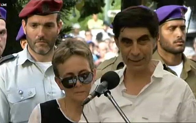 Simcha Goldin speaking at the funeral of his son Hadar at the Kfar Saba cemetery Sunday August 3, 2014. His wife Leah is at his side. (Screen capture: Ynet)
