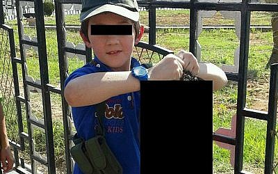 An edited photograph of a Sydney-born 7-year-old boy clutching the severed head of a Syrian soldier, presumably in Raqqa, Syria (photo credit: Twitter)