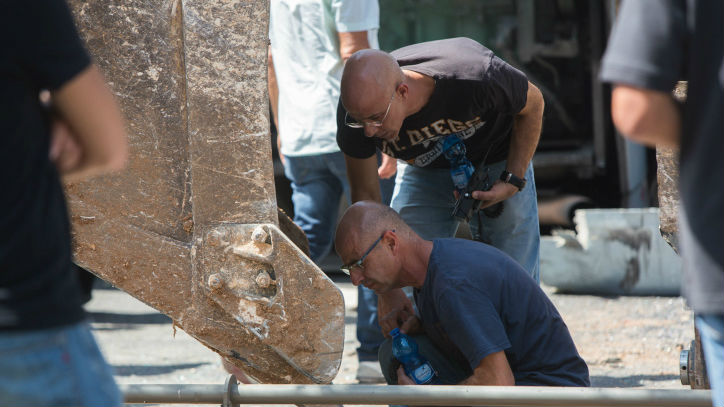 Security personnel inspect the scene where excavator driver Muhammed Naif El-Ja’abis, from the East Jerusalem neighborhood of Jabel Mukaber, overturned a bus on Shmuel HaNavi street in Jerusalem, August 4, 2014 (photo credit: Yonatan Sindel/Flash90) Security personnel inspect the scene where excavator driver Muhammed Naif El-Ja’abis, from the East Jerusalem neighborhood of Jabel Mukaber, overturned a bus on Shmuel HaNavi street in Jerusalem, August 4, 2014 (photo credit: Yonatan Sindel/Flash90)