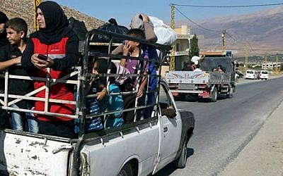 Lebanese citizens in the back of a pickup truck flee Arsal, a predominantly Sunni Muslim town near the Syrian border in eastern Lebanon, Monday, Aug. 4, 2014 (photo credit: AP/Bilal Hussein)