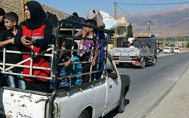 Lebanese citizens in the back of a pickup truck flee Arsal, a predominantly Sunni Muslim town near the Syrian border in eastern Lebanon, Monday, Aug. 4, 2014 (photo credit: AP/Bilal Hussein) Lebanese citizens in the back of a pickup truck flee Arsal, a predominantly Sunni Muslim town near the Syrian border in eastern Lebanon, Monday, Aug. 4, 2014 (photo credit: AP/Bilal Hussein)