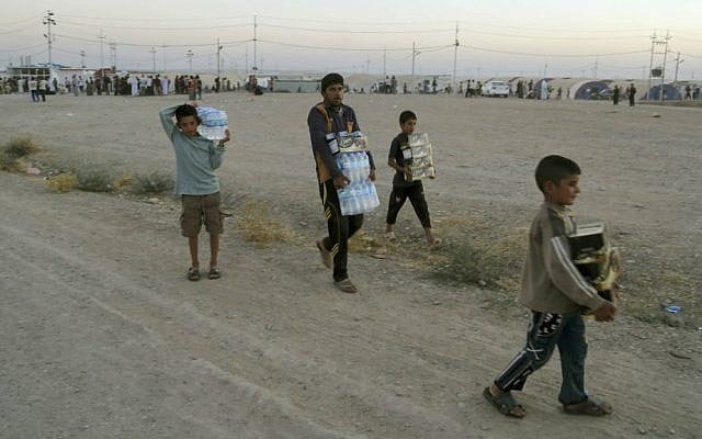 Displaced Iraqis from the Yazidi community carry humanitarian aid at the camp of Bajid Kandala at Feeshkhabour town near the Syria-Iraq border, in Iraq, Saturday, August 9, 2014. (AP/Khalid Mohammed) Displaced Iraqis from the Yazidi community carry humanitarian aid at the camp of Bajid Kandala at Feeshkhabour town near the Syria-Iraq border, in Iraq, Saturday, August 9, 2014. (AP/Khalid Mohammed)