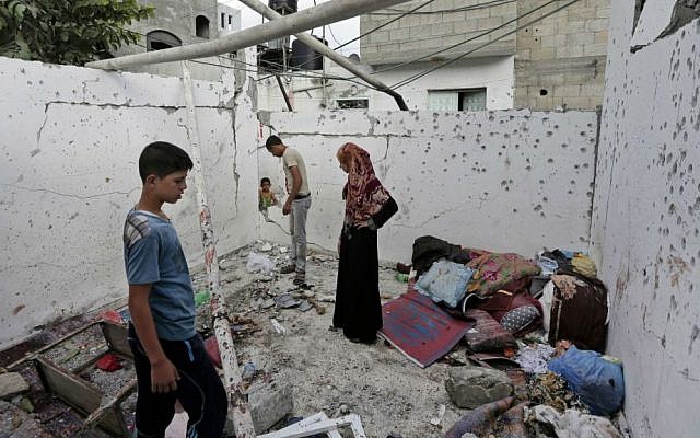 File: Palestinians inspect the damage to a house in the Jebaliya refugee camp that was hit by an Israeli strike in the northern Gaza Strip, Sunday, Aug. 3, 2014. (photo credit: AP/Lefteris Pitarakis) File: Palestinians inspect the damage to a house in the Jebaliya refugee camp that was hit by an Israeli strike in the northern Gaza Strip, Sunday, Aug. 3, 2014. (photo credit: AP/Lefteris Pitarakis)