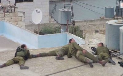 IDF soldiers apparently mocking a Palestinian who has just been shot in the leg. (screen capture: YouTube/ 
ISM Palestine)