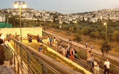 Gathering with members of the larger Hand in Hand community at Jerusalem's Train Track Park for a coexistence walk (photo credit: Jessica Steinberg/Times of Israel)