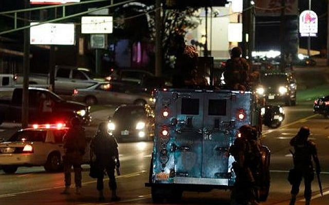 Police attempt to secure a street after a clash with protesters Wednesday, Aug. 13, 2014, in Ferguson, Mo. (photo credit: AP/Jeff Roberson) Police attempt to secure a street after a clash with protesters Wednesday, Aug. 13, 2014, in Ferguson, Mo. (photo credit: AP/Jeff Roberson)