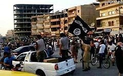 This undated file photo posted by the Raqqa Media Center, a Syrian opposition group, on Monday, June 30, 2014, which has been verified and is consistent with other AP reporting, shows fighters from extremist Islamic State group during a parade in Raqqa, Syria (AP/Raqqa Media Center, File)