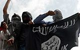 Illustrative photo of men holding up an Islamic State flag. (AFP/Tauseef Mustafa)
