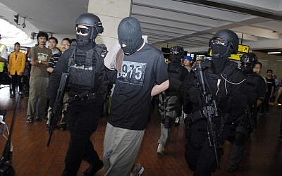Elite Indonesian anti-terror police from Densus 88 escort four Turks arrested on arrival at Jakarta airport on September 14, 2014. (photo credit: AFP Photo/Bima Sakti)