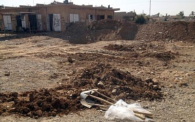 Shovels lie on the ground at the site where dozens of bodies were found in a mass grave on September 5, 2014 in Sulaiman Bek, 175 Km (108 miles) north of Baghdad. (photo credit: AFP/CAMILLE BOUISSOU )