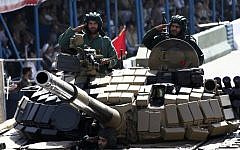 Iranian soldiers salute from a tank during the annual military parade marking the anniversary of Iran's war with Iraq (1980-88) in Tehran, on September 22, 2014 (Behrouz Mehri/AFP)