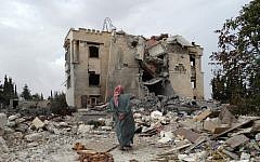 A Syrian man inspects the damage following a reported US-led coalition airstrike against the headquarters of al-Nusra Front, 20 km west of the northern city of Aleppo, on September 25, 2014. (photo credit: AFP/Sami Ali)